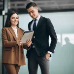 Two professionals reviewing a tablet
